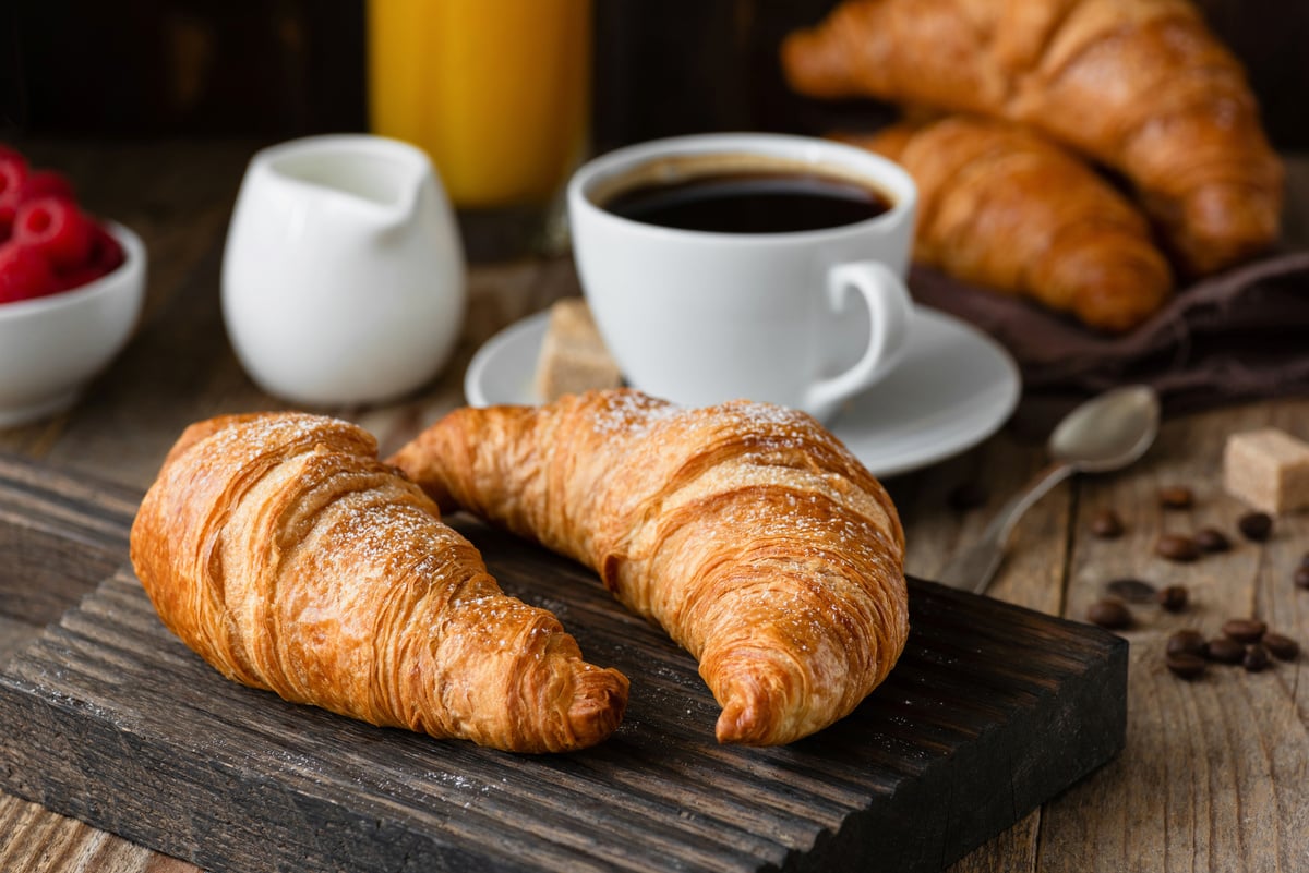 Breakfast with croissants, coffee, orange juice and berries